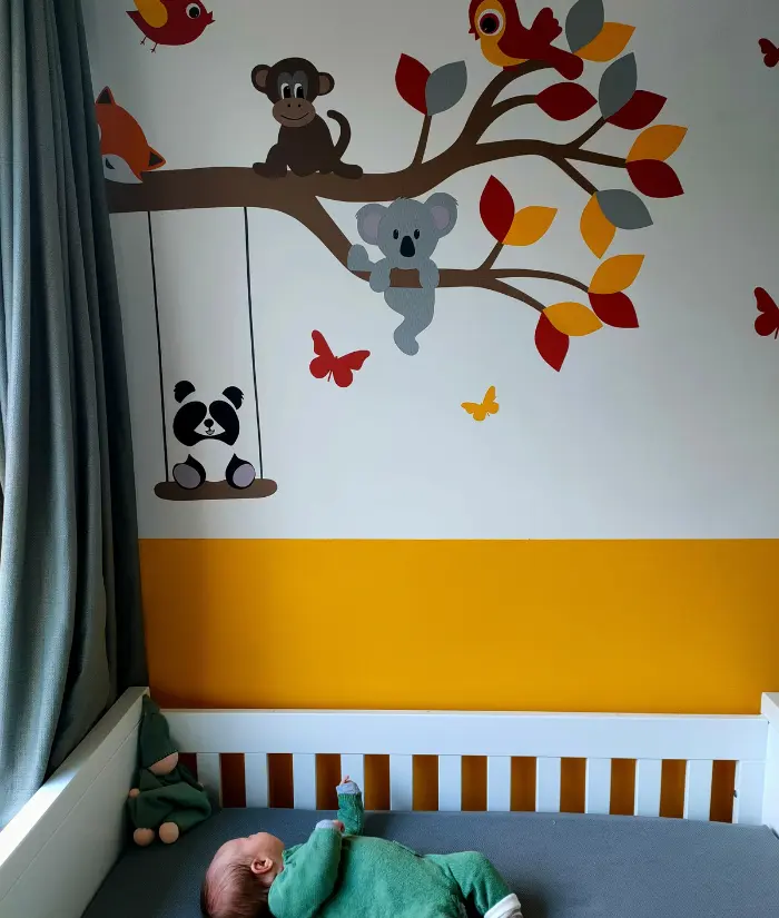 Baby in okergele babykamer